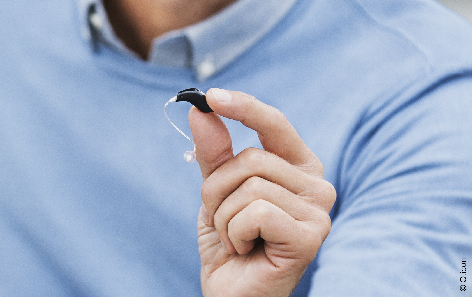 Hand holding hearing aid